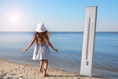 Weather thermometer and little child running on sandy beach. Heat stroke warning