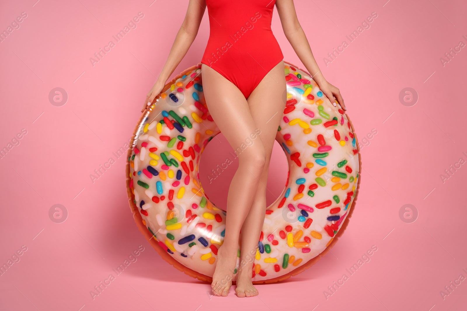 Photo of Young woman with inflatable ring against pink background, closeup