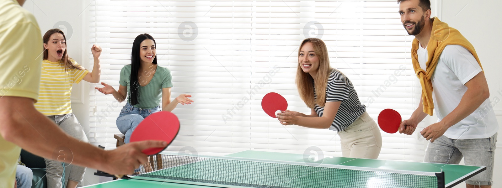 Image of Happy friends playing ping pong together indoors. Banner design