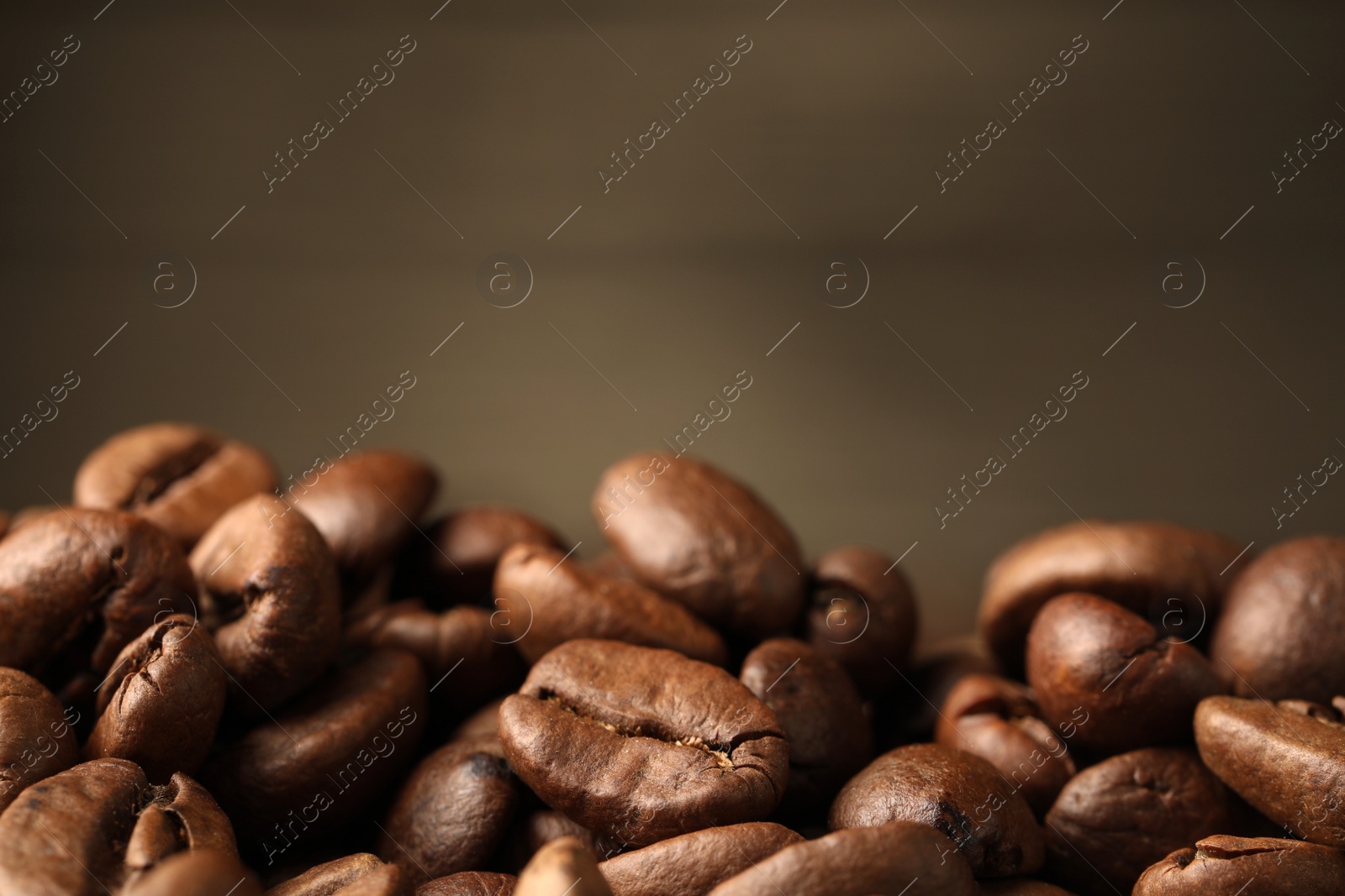 Photo of Heap of aromatic roasted coffee beans, closeup