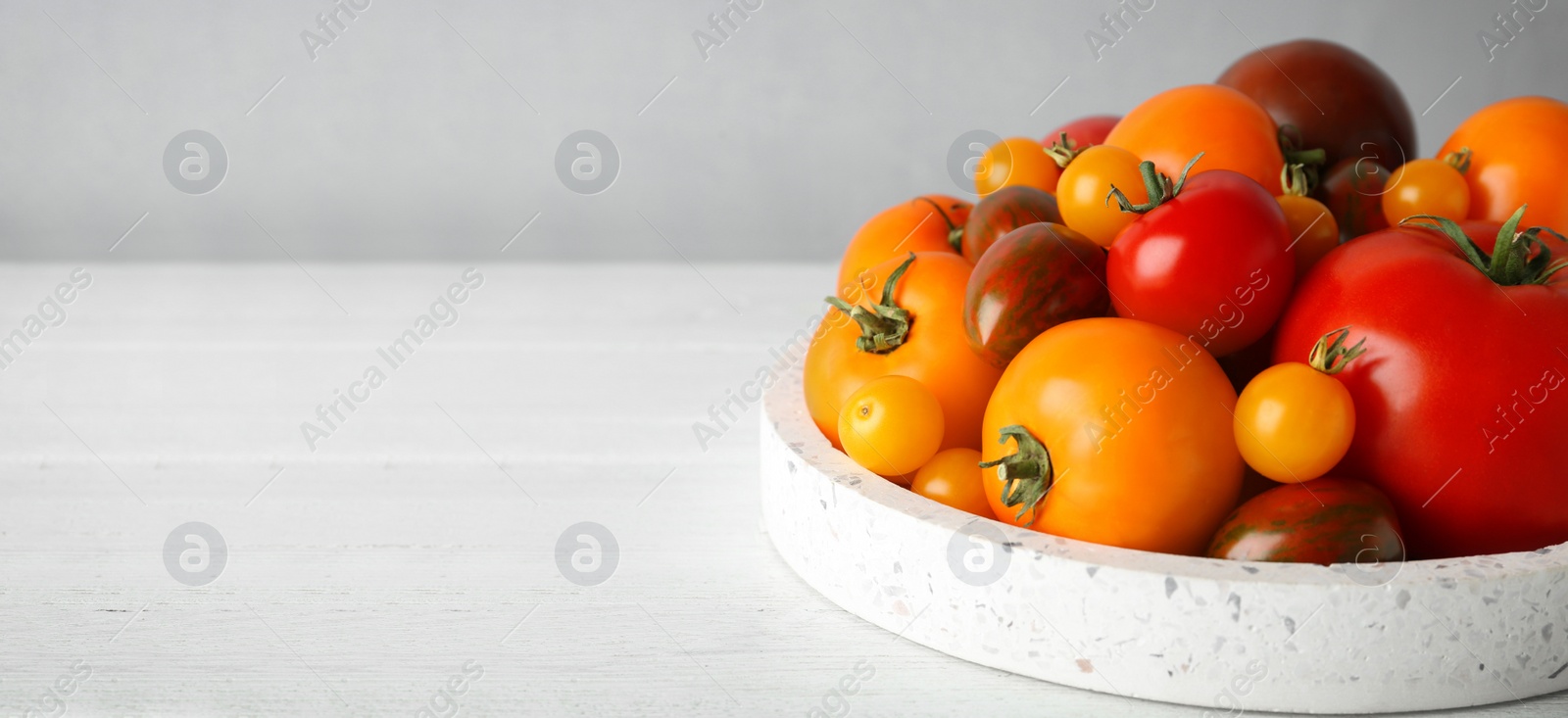 Image of Fresh cherry tomatoes on white table, space for text. Banner design 