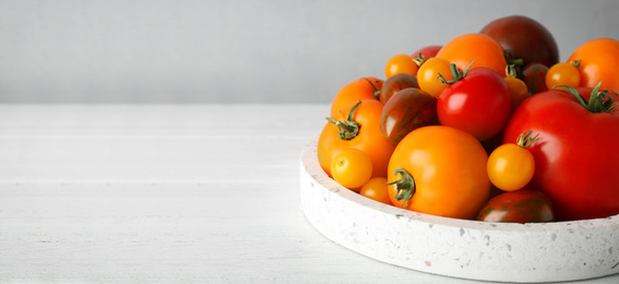 Image of Fresh cherry tomatoes on white table, space for text. Banner design 