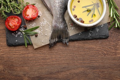 Fresh dorado fish and ingredients on wooden table, flat lay, space for text