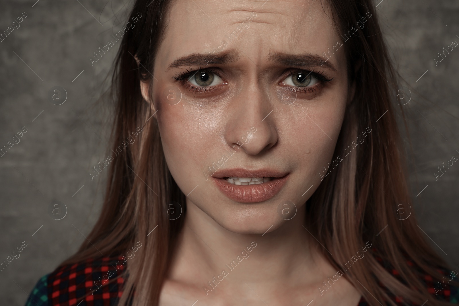 Photo of Abused young woman on grey background. Stop violence