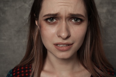 Photo of Abused young woman on grey background. Stop violence