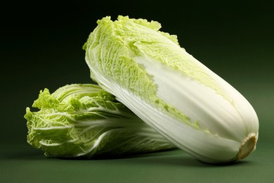 Photo of Fresh ripe Chinese cabbages on green background, closeup