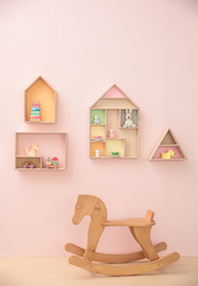 Photo of Stylish baby room interior design with house shaped shelves and rocking horse