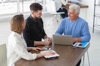 Mature manager consulting couple in office