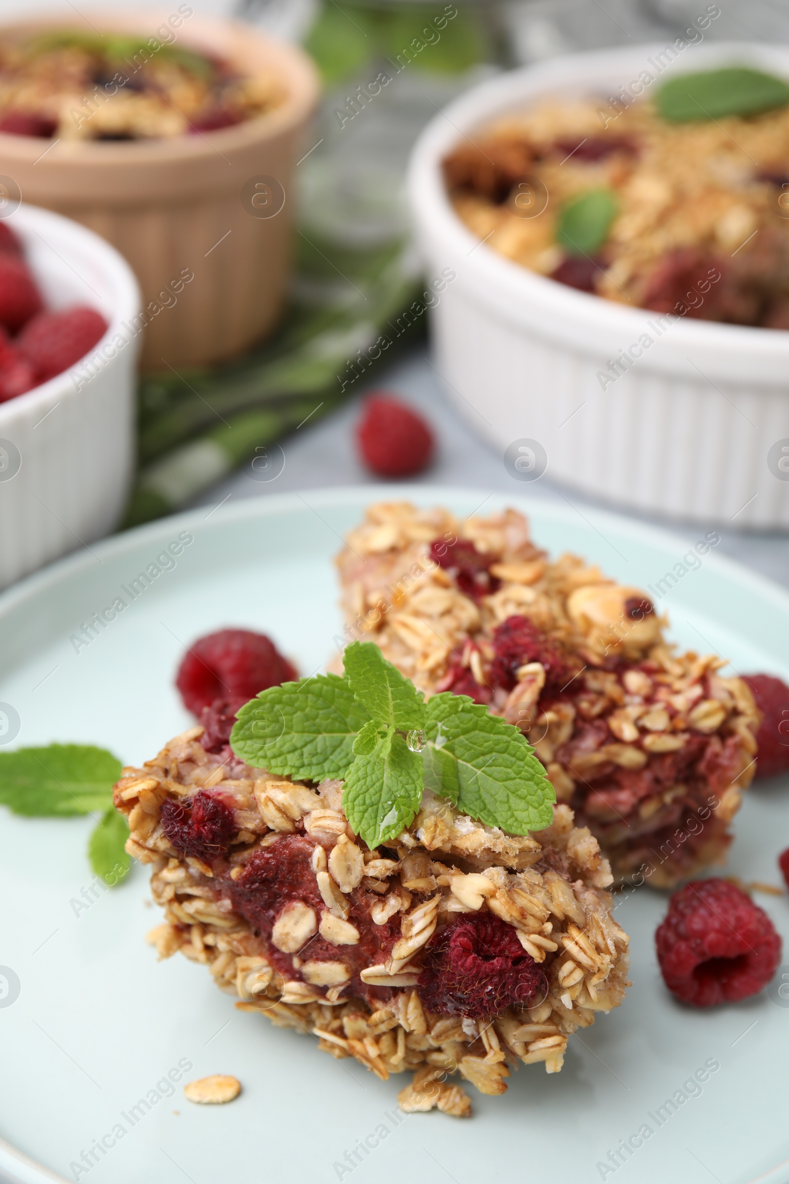 Photo of Tasty baked oatmeal with raspberries on table, closeup