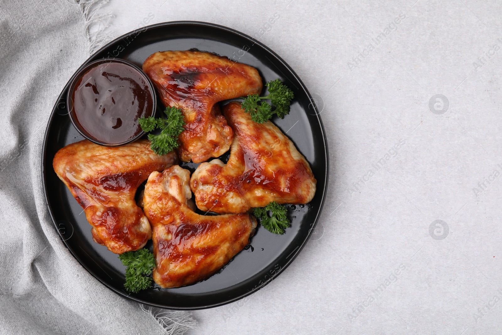 Photo of Fresh marinade and chicken wings on light table, top view. Space for text