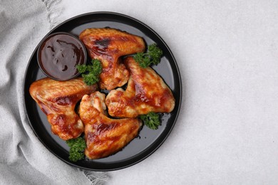 Photo of Fresh marinade and chicken wings on light table, top view. Space for text