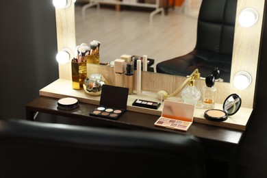 Makeup room. Cosmetic products and perfumes on wooden dressing table indoors