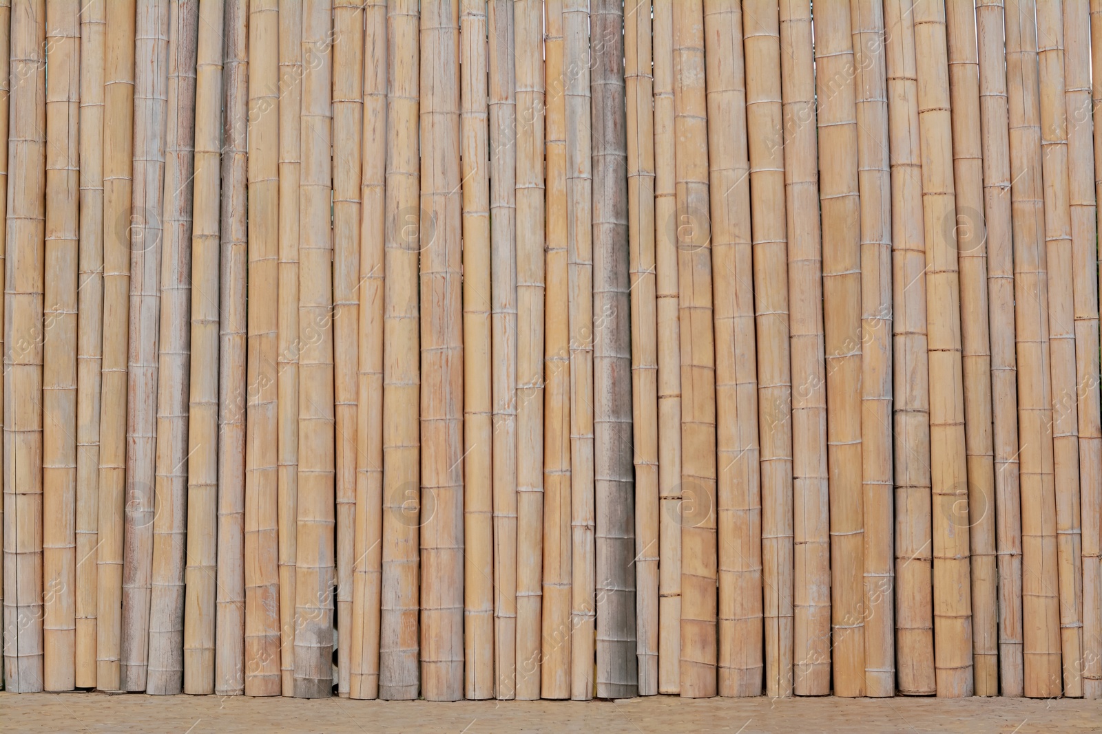 Photo of Fence made with dry bamboo sticks as background, closeup