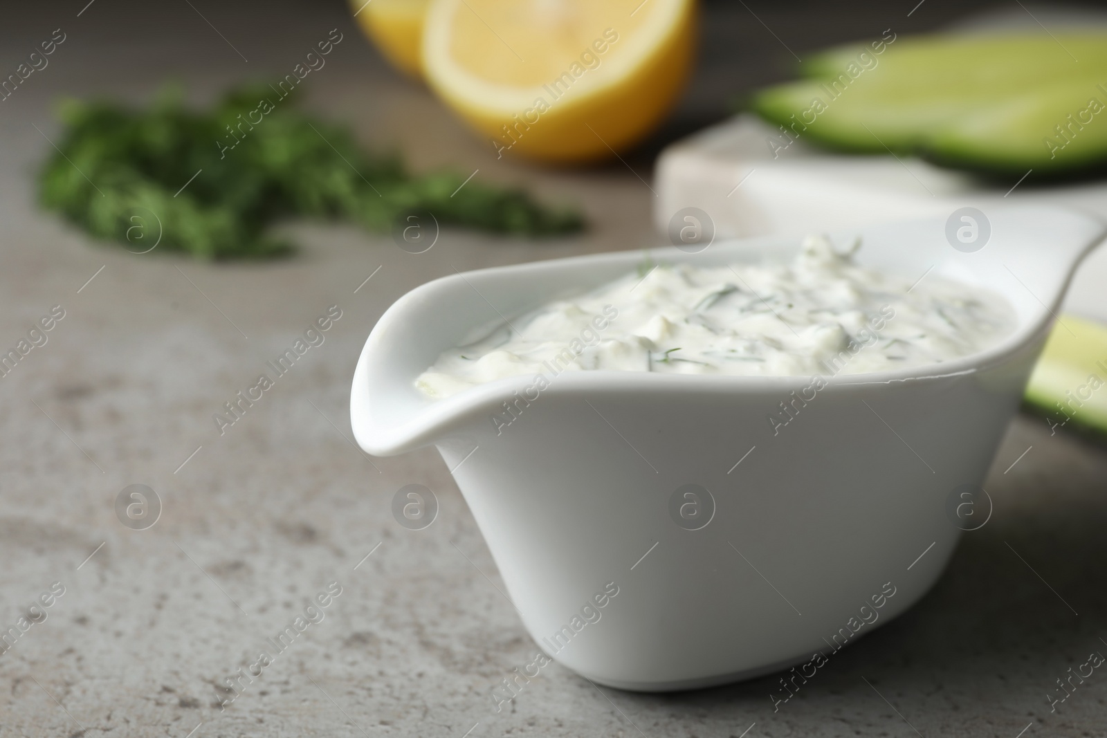 Photo of Ceramic dish of Tzatziki cucumber sauce on table. Space for text