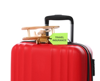 Red suitcase with TRAVEL INSURANCE label on white background, closeup