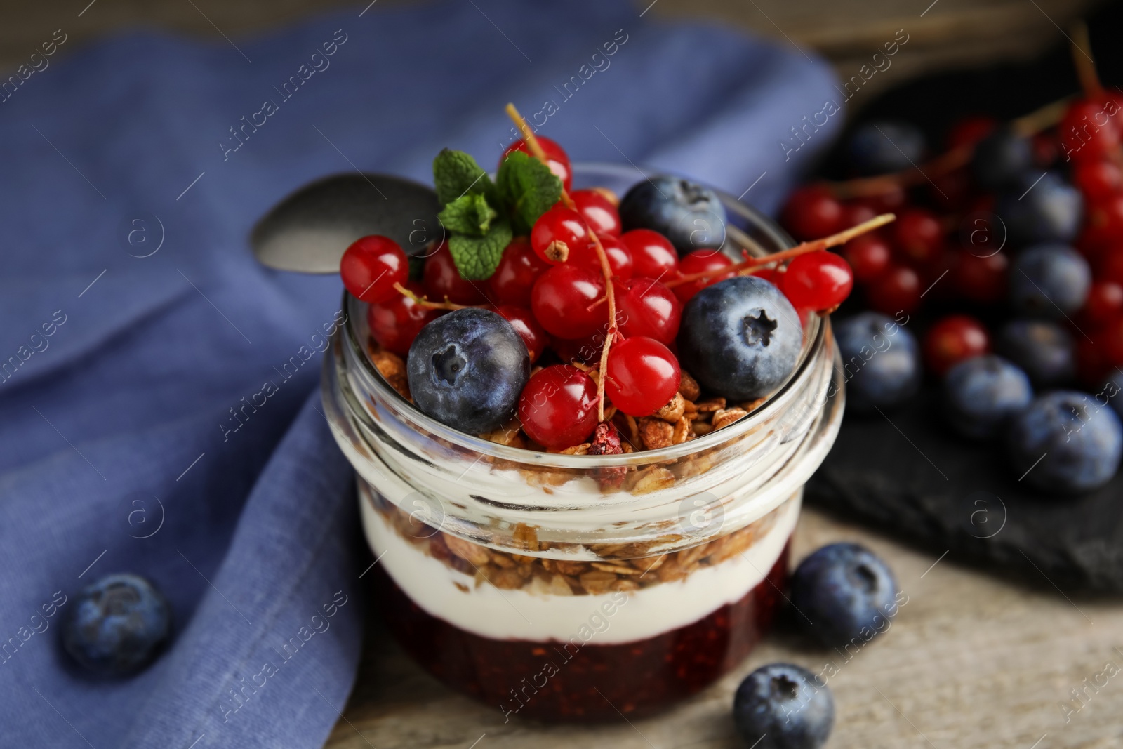 Photo of Delicious yogurt parfait with fresh berries and mint on table, closeup