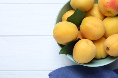 Photo of Delicious fresh ripe apricots on white wooden table, flat lay. Space for text