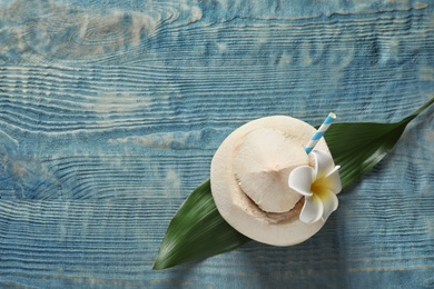 Photo of Composition with fresh coconut drink in nut on wooden background