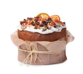 Photo of Traditional Easter cake with sprinkles and dried fruits in parchment paper isolated on white