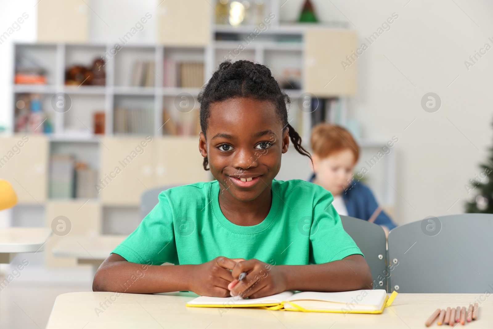 Photo of Portrait of smiling little boy studying in classroom at school