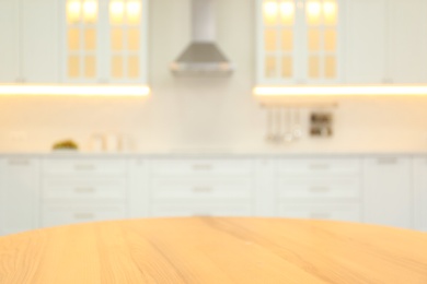 Photo of Wooden table and blurred view of modern kitchen interior on background