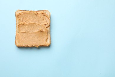 Photo of Tasty peanut butter sandwich on light blue background, top view. Space for text