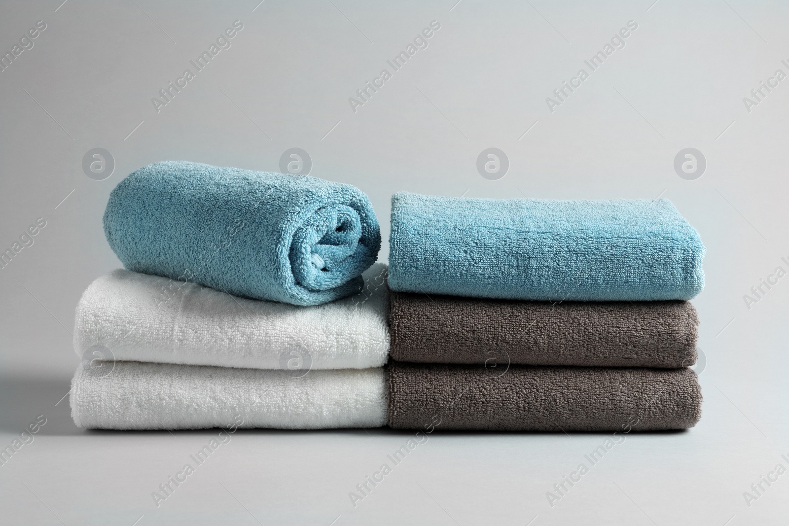 Photo of Fresh fluffy folded towels on grey background