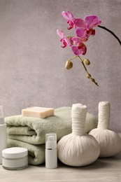 Photo of Composition with spa products and beautiful flower on grey wooden table