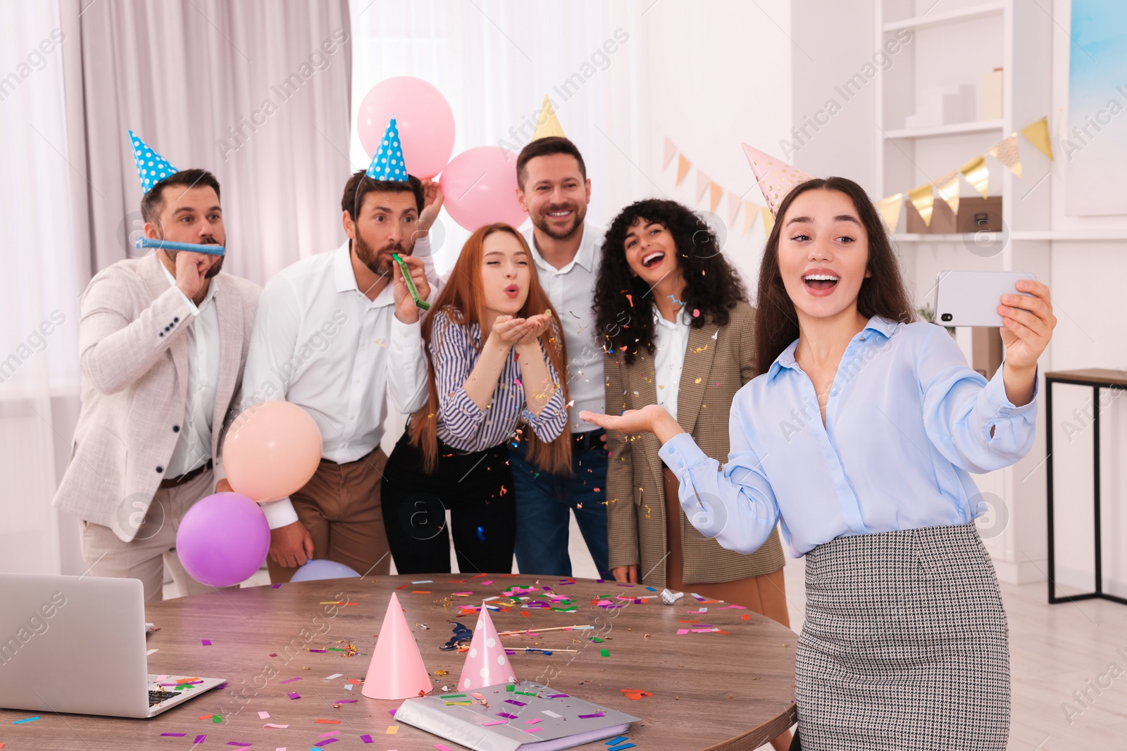 Photo of Coworkers taking selfie during office party indoors