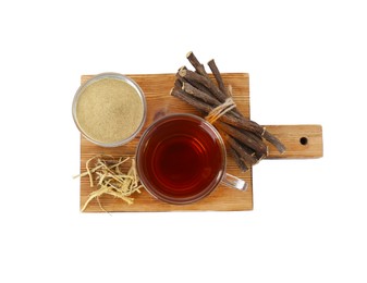 Aromatic licorice tea in cup, dried sticks of licorice root and powder isolated on white, top view