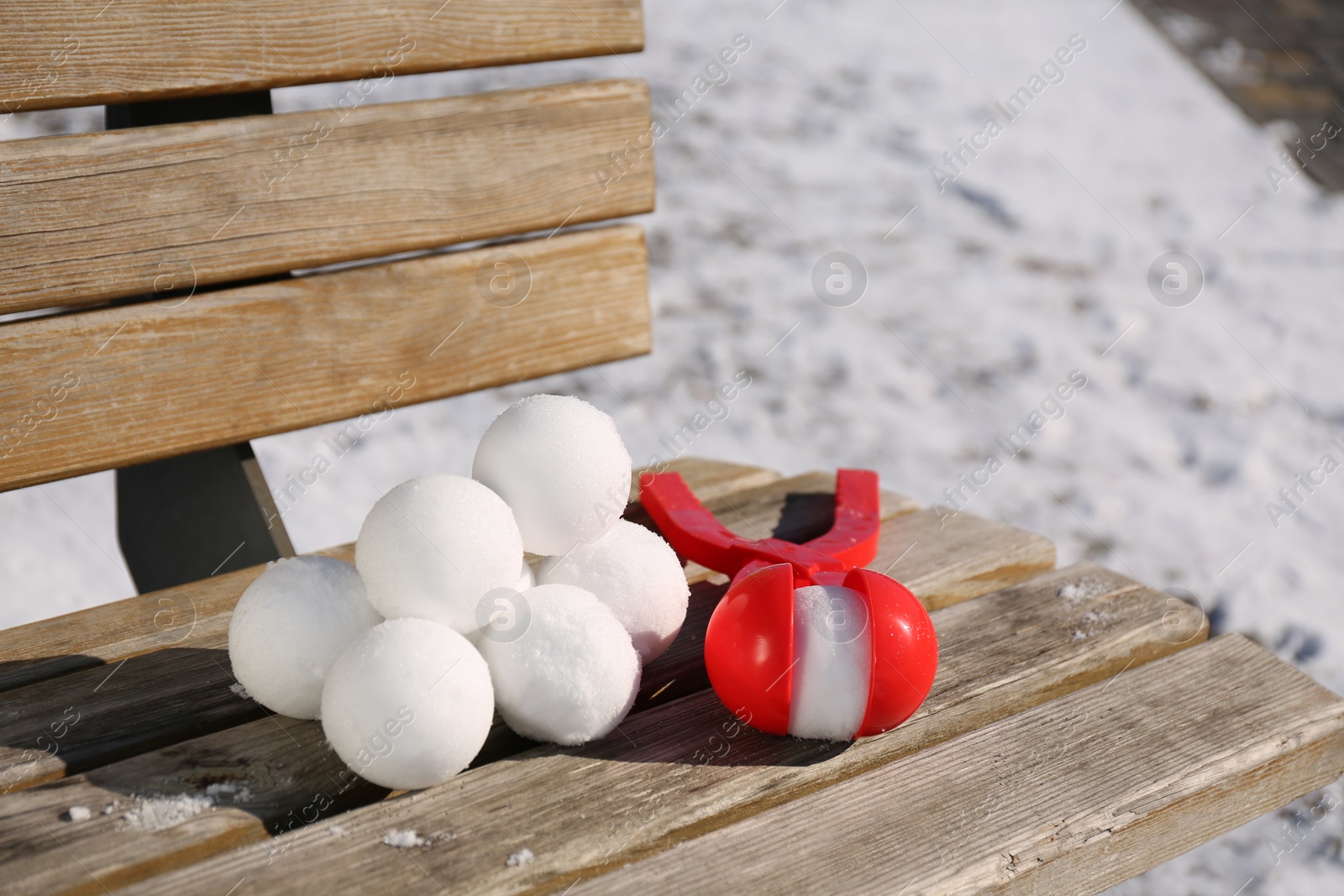 Photo of Snowballs and plastic tool on bench outdoors