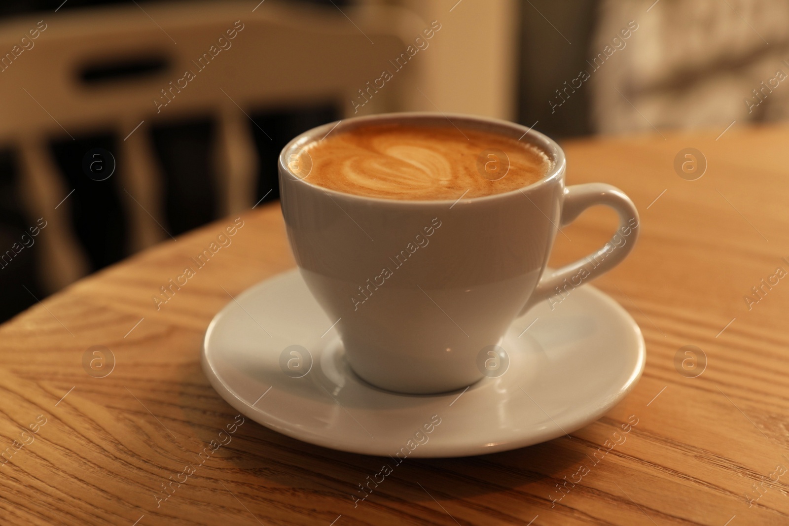 Photo of Cup of aromatic hot coffee on wooden table in cafe, closeup