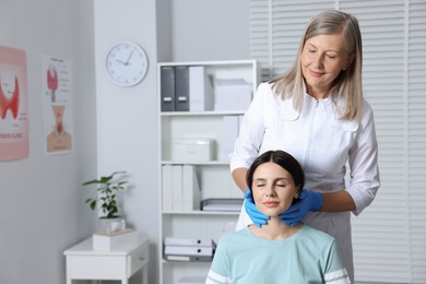 Photo of Endocrinologist examining thyroid gland of patient at hospital