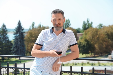 Photo of Man with glass of red wine outdoors