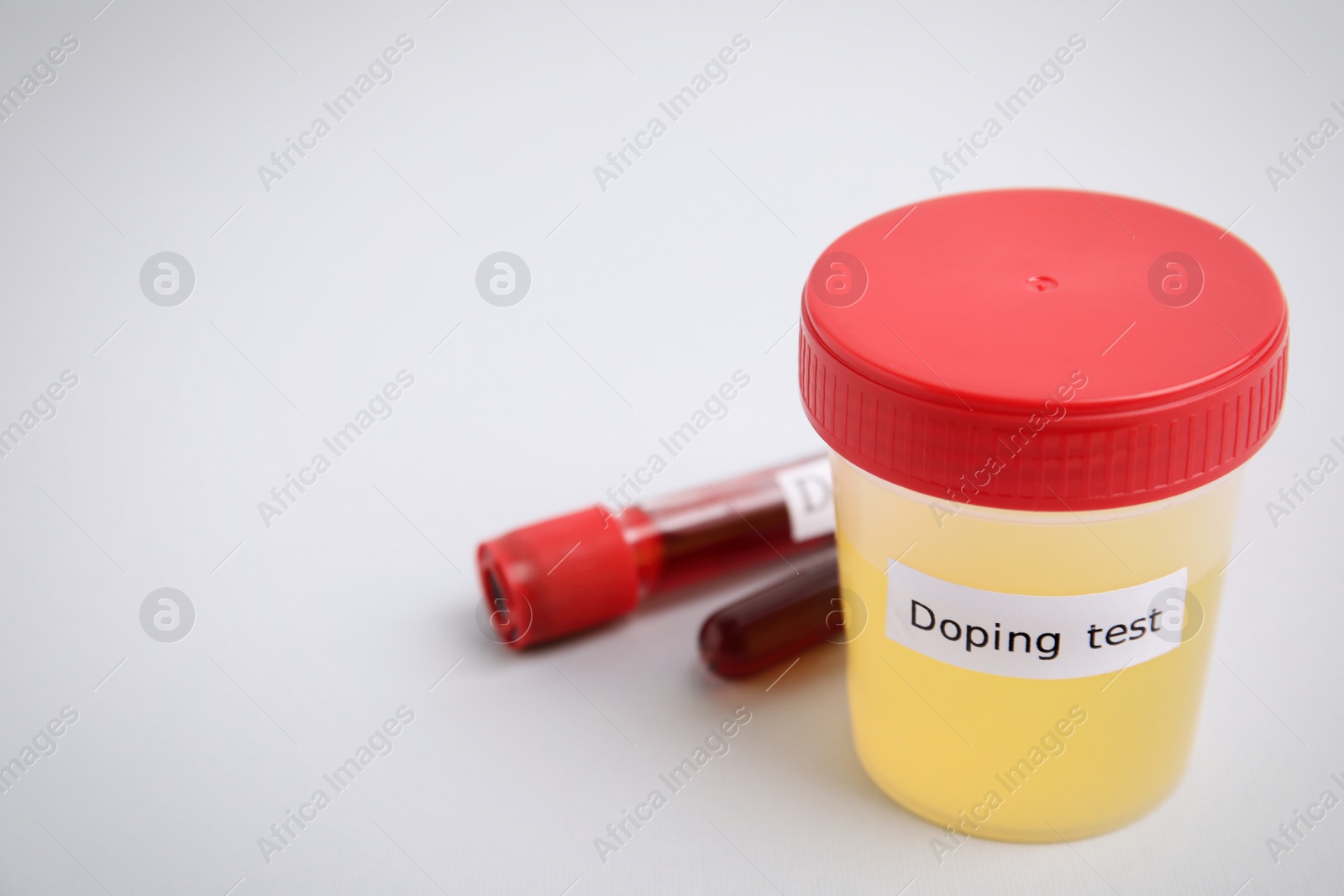 Photo of Jar with urine sample on light grey background, space for text. Doping control