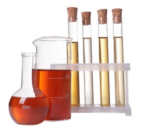 Different laboratory glassware with brown liquids on white background