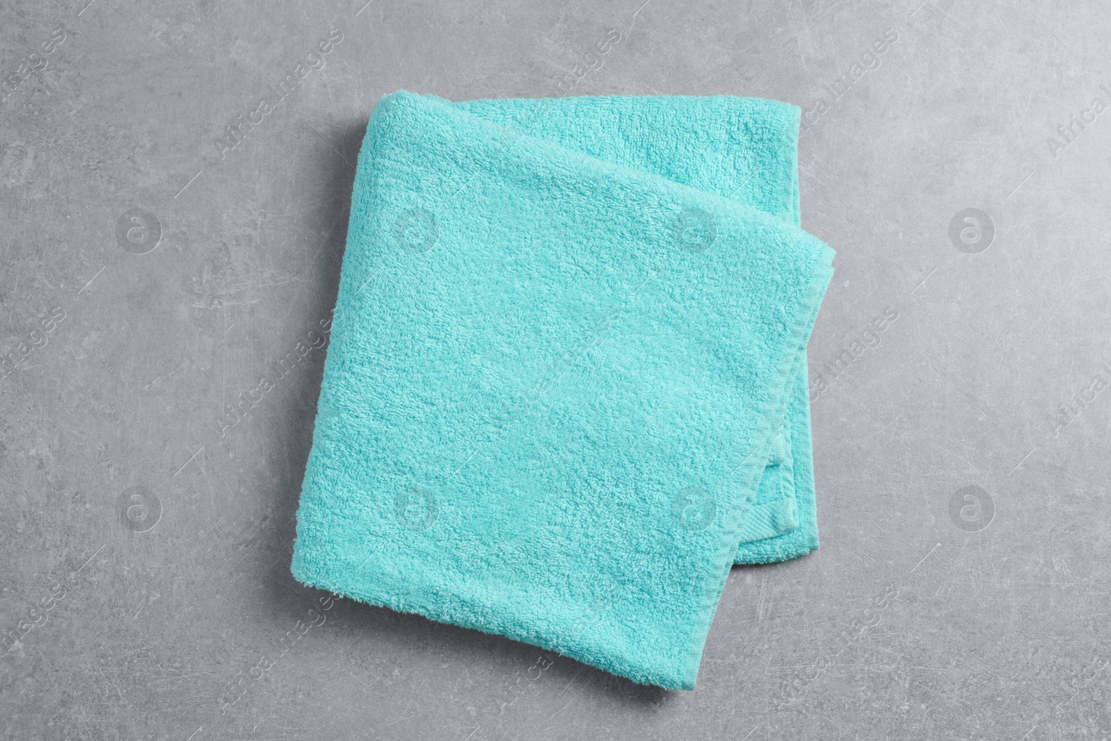 Photo of Soft folded towel on gray background, top view