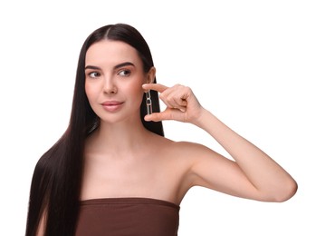 Beautiful young woman holding skincare ampoule on white background