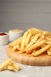 Photo of Delicious french fries on light grey marble table
