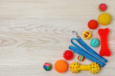 Photo of Flat lay composition with dog leash and toys on white wooden background, space for text