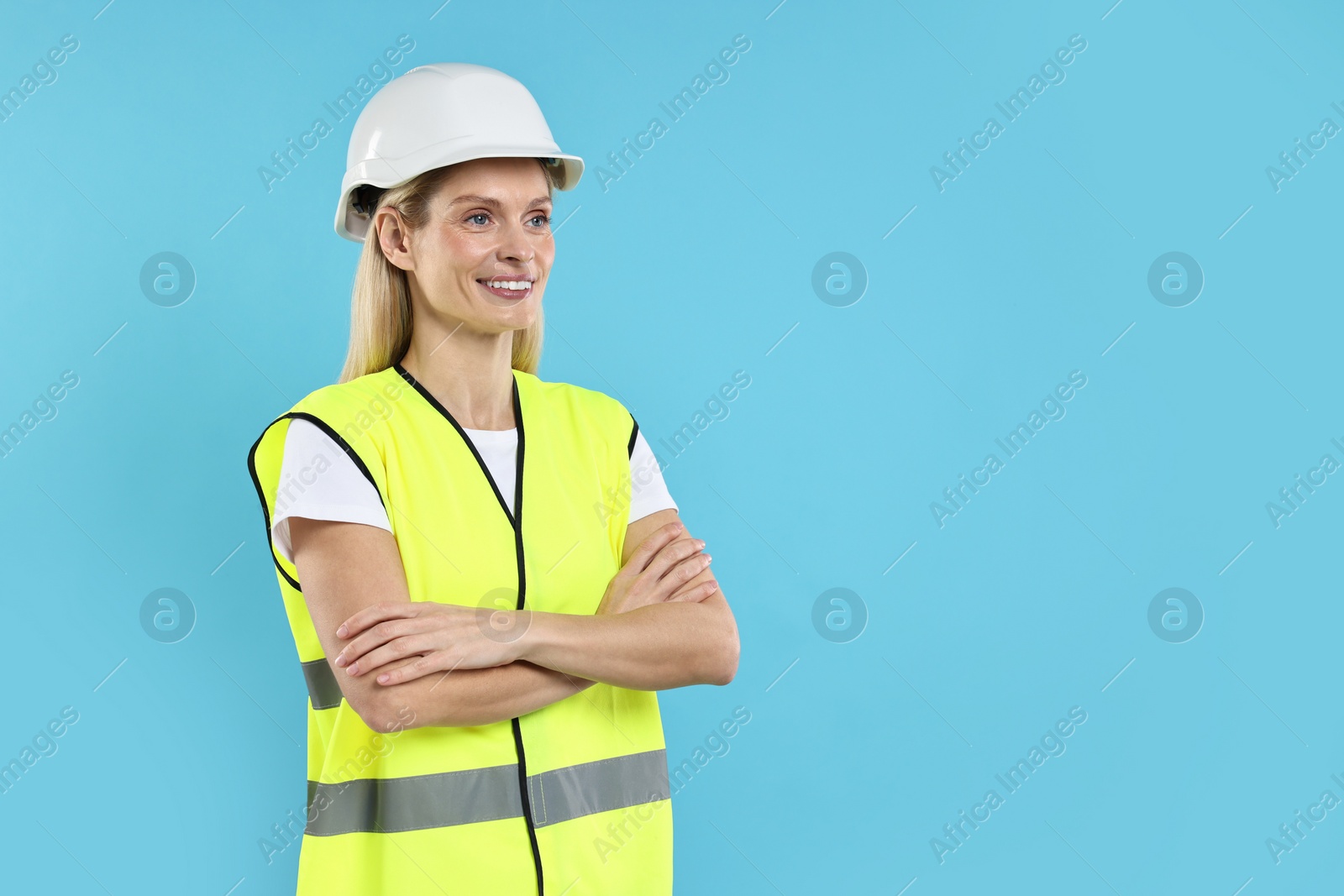 Photo of Engineer in hard hat on light blue background, space for text