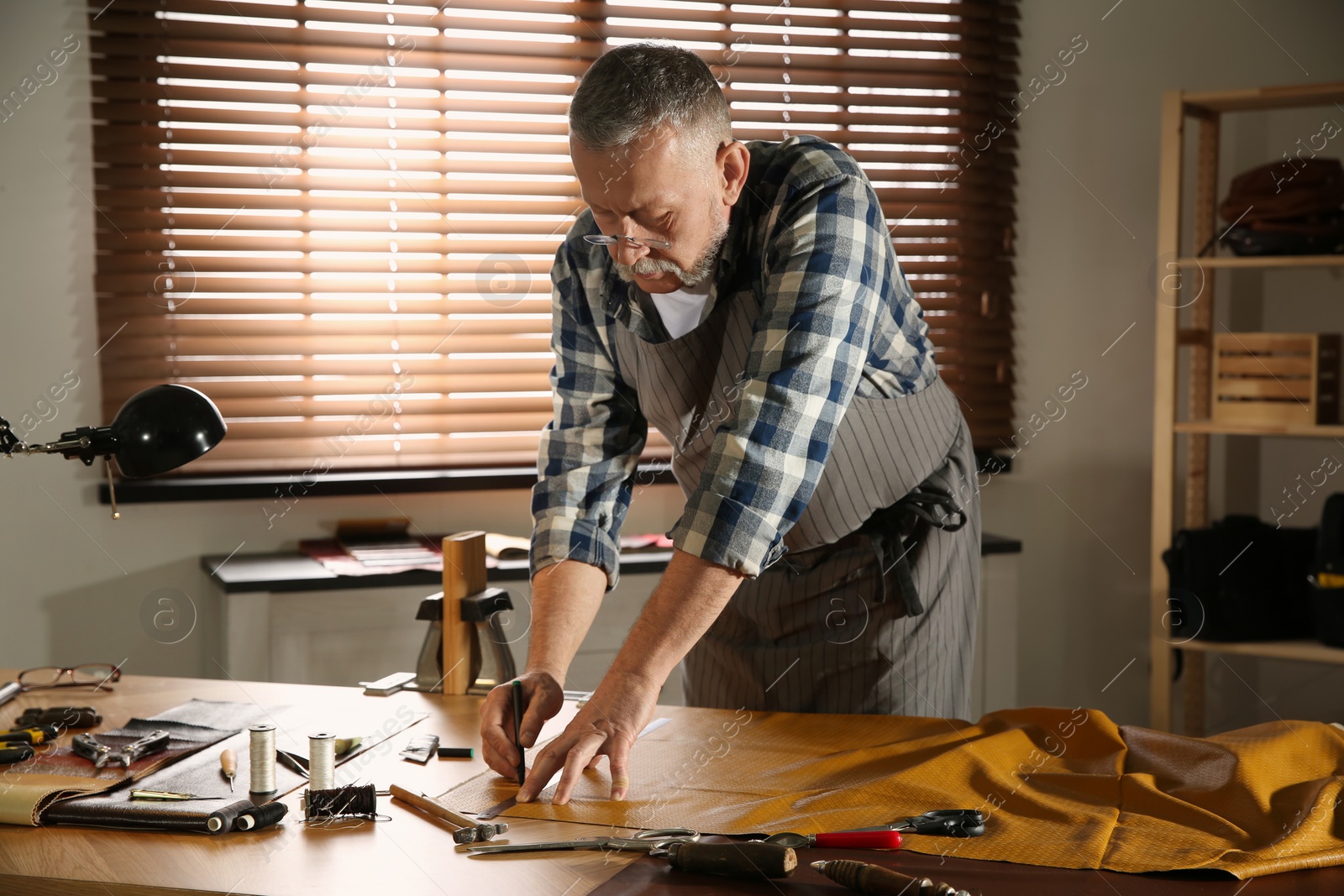 Photo of Man working with piece of leather in workshop