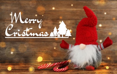 Image of Merry Christmas! Cute gnome with candy canes on table against wooden background, bokeh effect