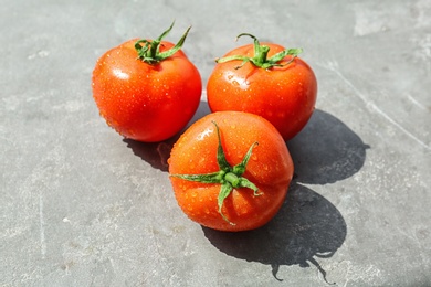 Photo of Fresh ripe tomatoes with water drops on grey background