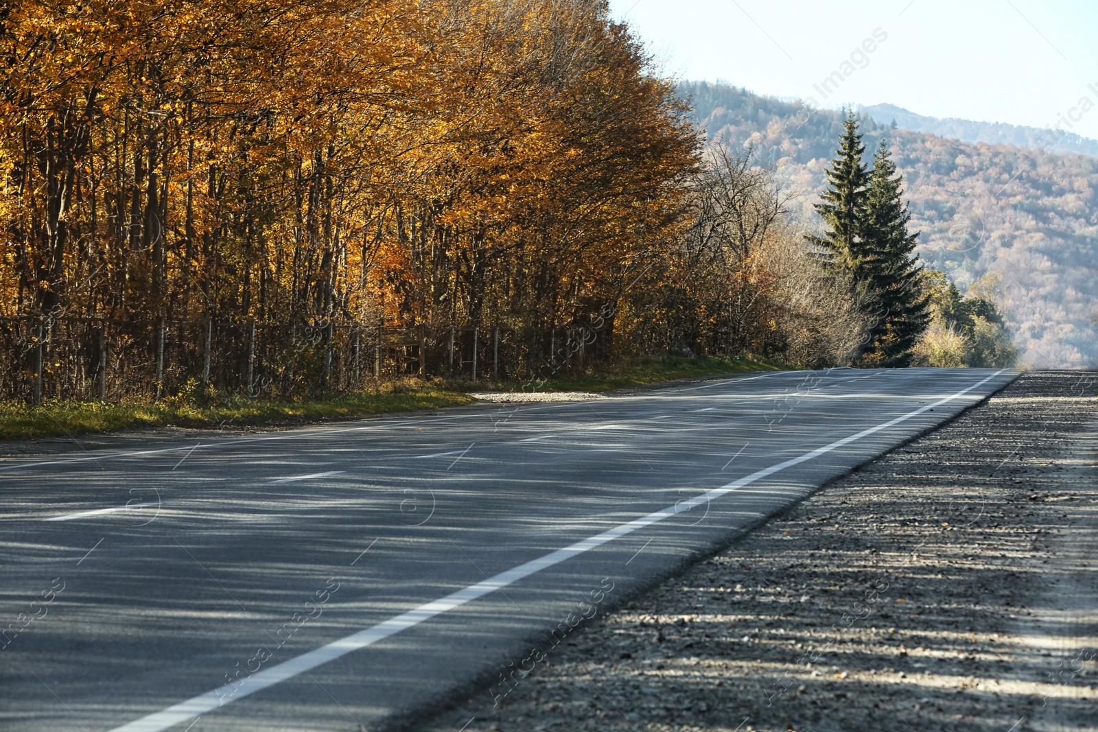 Photo of Asphalt road running through countryside on sunny day