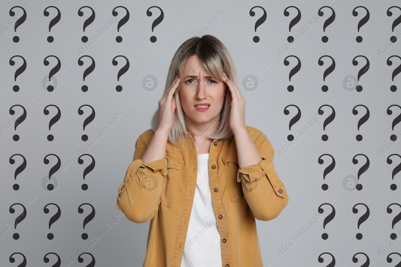 Image of Amnesia. Confused woman and question marks on light grey background