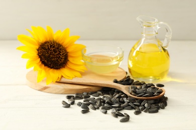 Photo of Composition with sunflower oil on white wooden table