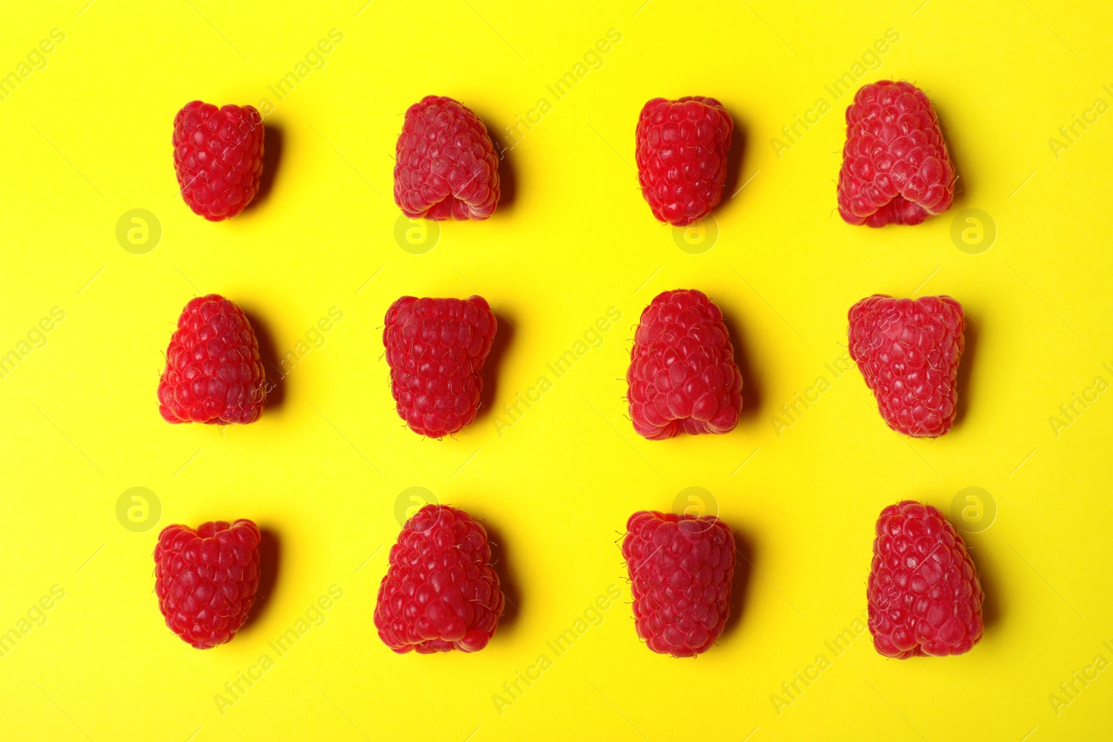 Photo of Flat lay composition with delicious ripe raspberries on yellow background