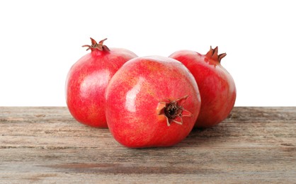 Photo of Fresh pomegranates on wooden table against white background