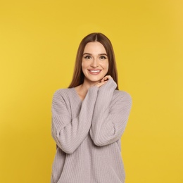 Photo of Beautiful young woman in sweater on yellow background. Winter season